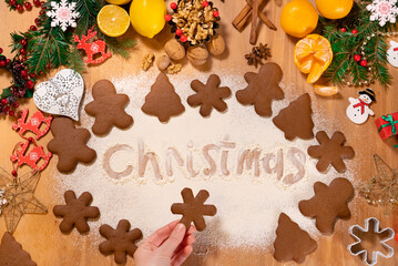 Christmas gingerbread in the form of snowflakes in the hands of a girl on the background of Christmas decor, top view
