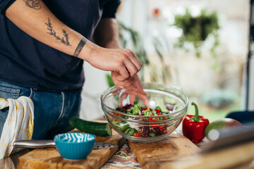 close up man salting salad