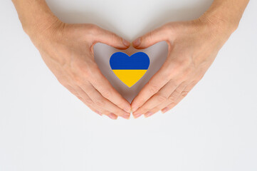 The national flag of Ukraine in female hands. The concept of patriotism, respect and solidarity with the citizens of Ukraine.