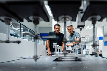 Engineers discussing over machinery at factory