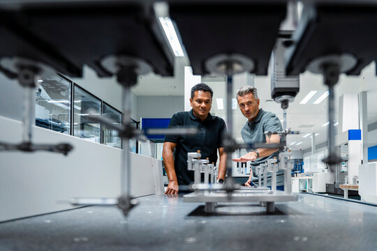 Engineers discussing over machinery at factory