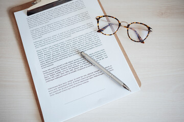Agreement contract with pen and eyeglasses at office desk
