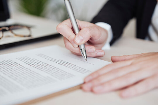 Real estate agent signing document at office