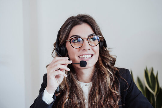 Customer service representative with eyeglasses talking on headset at office