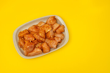 raw meat with marinate on brown dish on yellow