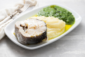 boiled fish with mashed potato and spinach on white dish