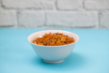 dry yellow grapes in small white bowl