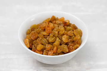 dry yellow grapes in small white bowl
