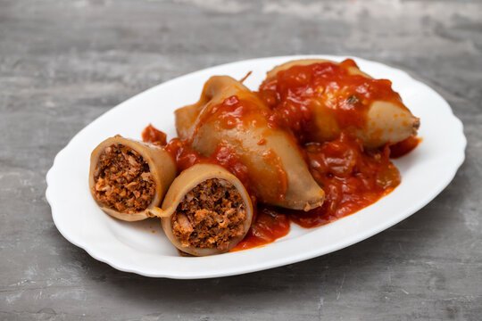 stuffed squids with sauce on white dish