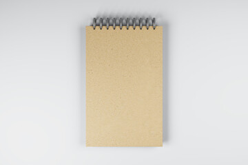 Top view and close up of brown spring notepad on white desktop background. Mock up place for your advertisement. Education, work, supplies and stationery concept. 3D Rendering.