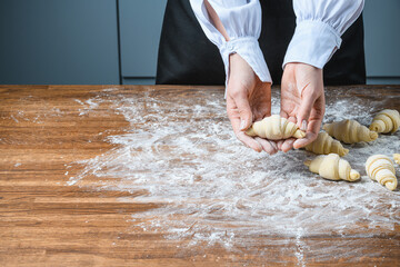 The chef manually makes croissants on the table with ingredients.