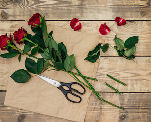 The florist creates a floral arrangement of roses, pruning the stem with scissors.Festive mood.
