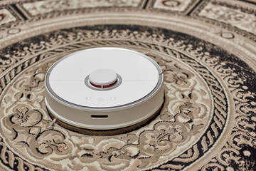 White robot vacuum cleaner isolated on beige carpet