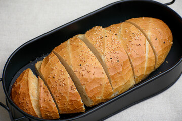 Sliced Sesame Bread in a Black Bread bin