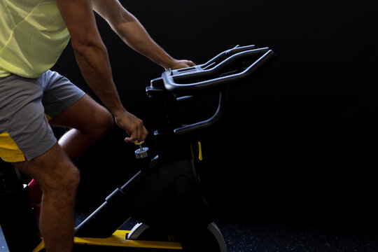 Sportsman cycling exercise bike at gym