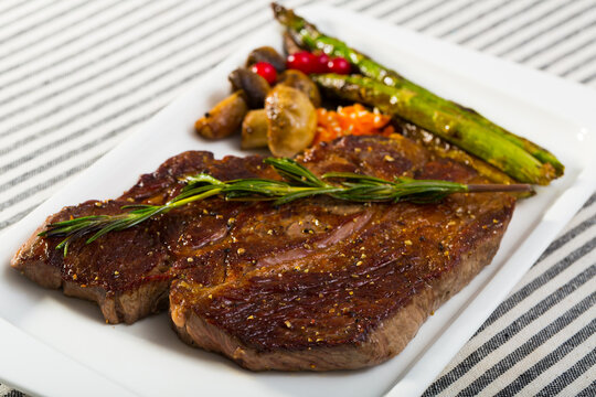 Photography of plate with beef entrecote with mushroom and asparagus in restaurante.