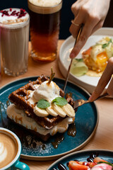 Attractive brutal tattooed young man is eating dessert, cute and bruital together