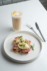Ham and poached egg waffle, restaurant gourmet breakfast on big white dish