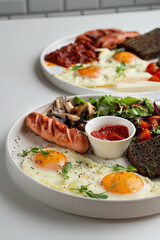 Full english breakfast with vegetables and roasted sausage,served with rye toasts and sunny side up eggs, menu photoshoot