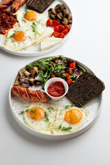 Full english breakfast with vegetables and roasted sausage,served with rye toasts and sunny side up eggs, menu photoshoot