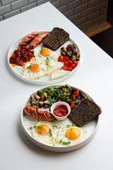 Full english breakfast with vegetables and roasted sausage,served with rye toasts and sunny side up eggs, menu photoshoot