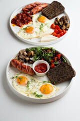 Full english breakfast with vegetables and roasted sausage,served with rye toasts and sunny side up eggs, menu photoshoot