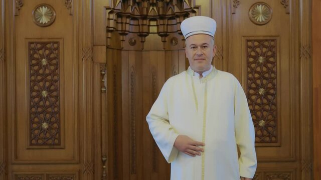 A Muslim cleric adjusting his clothes for Friday prayers.Portrait of Muslim cleric.