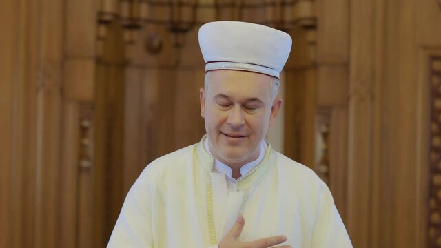Portrait of Muslim cleric.A Muslim cleric greets the congregation who came to the mosque for Friday prayers. Muslim greeting.