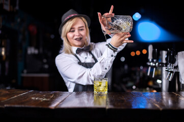 Girl barman concocts a cocktail at the pothouse
