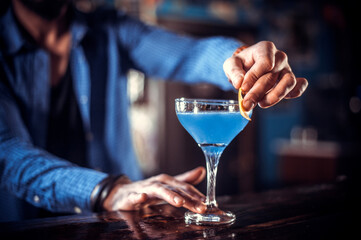 Charming barkeeper demonstrates his skills over the counter at the nightclub