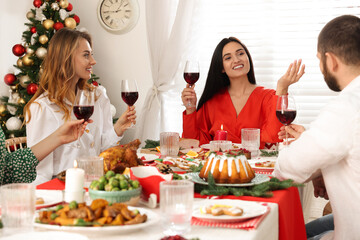 Happy family with their friends enjoying festive dinner at home. Christmas Eve celebration