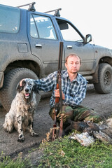 Hunter with prey, gun and English setter. Krasnoyarsk, Russia