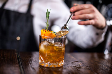 Charming girl bartender makes a cocktail at the nightclub