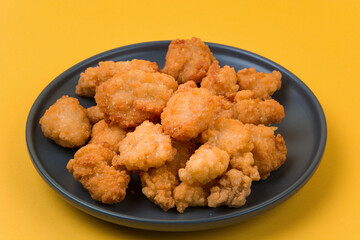 A plate of fried chicken with yellow background