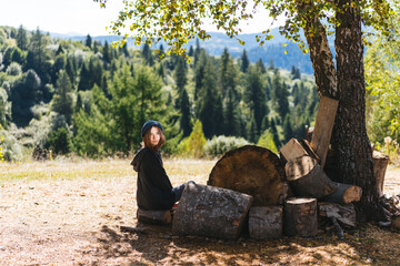 Naklejka na ściany i meble Woman next to logs of cut wood