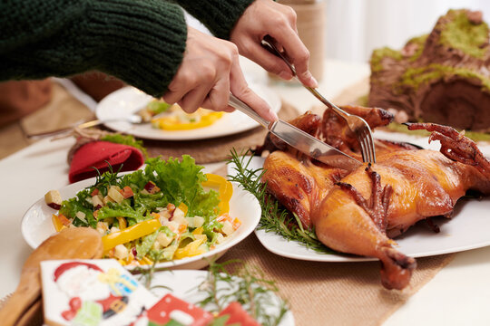 Close-up image of woman cutting fried chicken for every guest at Chirstmas party