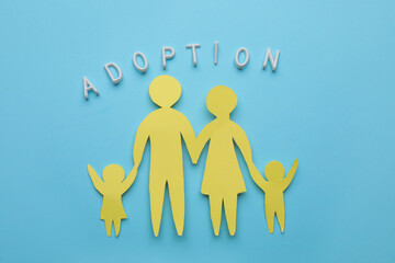 Family figure and word Adoption on light blue background, flat lay