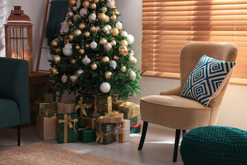 Armchair near Christmas tree and gift boxes in room