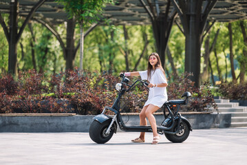 Young beautiful woman and an electric scooter, ecological transport