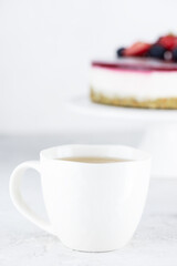 A cup of green tea on the background of a vegan cauliflower cake with berries. Sugar, gluten and lactose free.