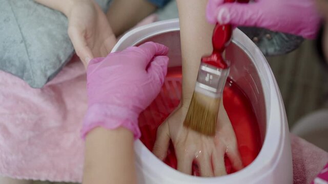Unrecognizable woman having a hand paraffin spa.