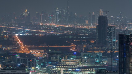 Fototapeta na wymiar Dubai Downtown skyline row of skyscrapers with tallset tower aerial night timelapse. UAE