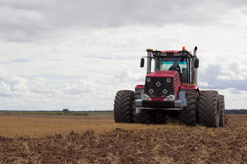 modern tractor in field cultivating soil