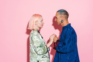 Young white couple in chinese jackets holding hands together