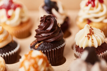 Viele bunte Cupcakes mit Schokolade und anderen Cremes