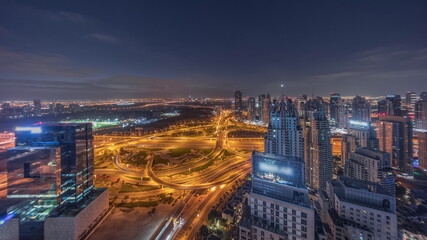 Fototapeta premium Huge highway crossroad junction between JLT district and Dubai Marina night to day timelapse.