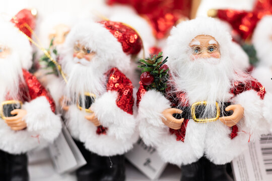 lots of Santa Claus on the store shelf in red suits