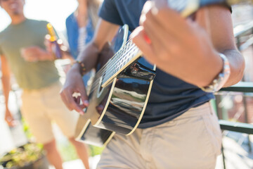 Close-up of dark acoustic guitar. Man playing guitar, hands on strings. Party, music, hobby concept