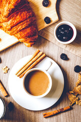 Breakfast with coffee and croissants on wooden table