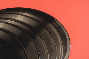 Old vinyl records on a red background. A group of gramophone rec